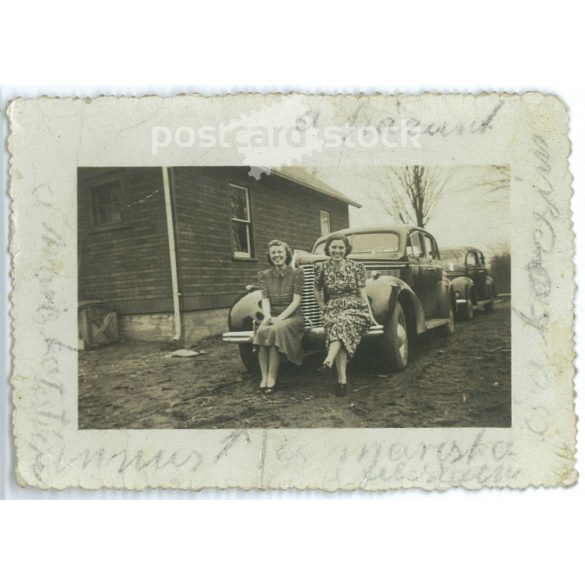 Young cheerful lady brother and sister sitting on the bumper of a car. 1920s (2791795)