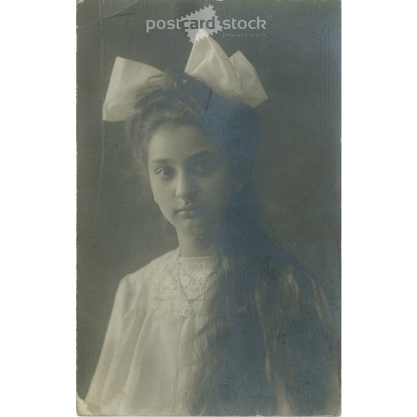 Young girl with long hair with bow. Original paper image. Postcard, photo sheet. 1920s. (2791798)