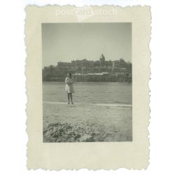   Young woman on the bank of the Danube after the liberation, with the bombed-out Buda Castle in the background. Original small paper image. (2792015)