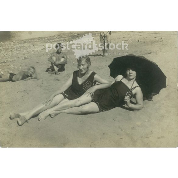 Ladies sunbathing on the beach with umbrella and bystanders. Original paper image. Postcard, photo card. (2792028)