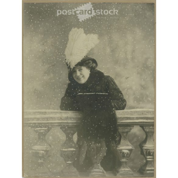 1910s. Elegant woman in feathered hat, snowfall, studio shot. Original cashiered paper image. Its maker is unknown. (2792250)