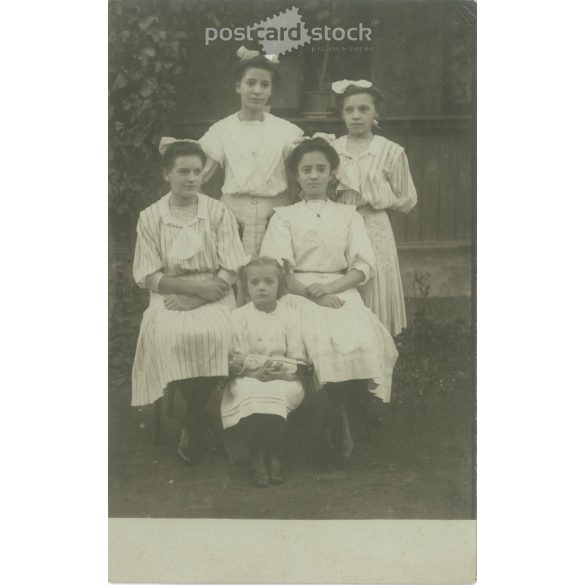 The picture may have been taken in Hungary in the 1910s. Sisters in white in front of the porch. Old postcard, photo sheet. (2792360)