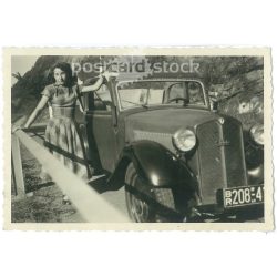   1950s. Germany. Young woman next to her car in the mountains. The creator of the image is unknown. Black and white original paper image, old photo. (2792426)