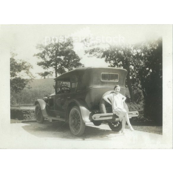 1930s. Germany. Car rest area. Young woman posing sitting on the bumper of the car. Its maker is unknown. Black and white original paper image, old photo. (2792430)