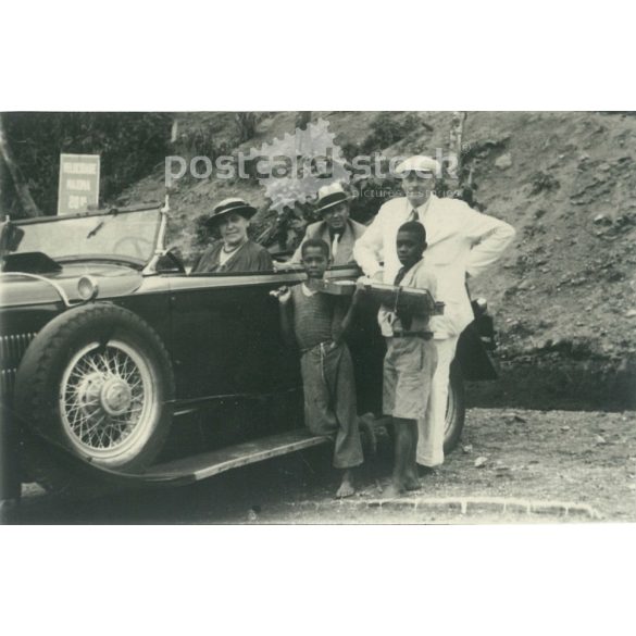 1930s. Presumably in some English colonial territory. The picture was taken at a car rest stop. Its maker is unknown. Black and white original paper image, old photo. (2792436)