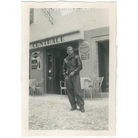 1964 – Young man in front of a cafe. Made by FOKI Foto photography studio. Black and white original paper image, old photo. (2792453)