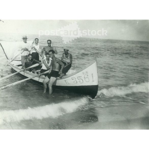 1932. Germany. Young men with a boat on the sea. The picture was taken by the Foto Regal studio. Black and white original paper image, old photo. (2792465)