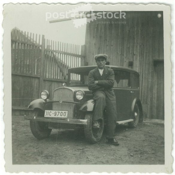 1920s. Germany. Young man sitting on the car in front of the shed. Black and white original paper image, old photo. (2792474)