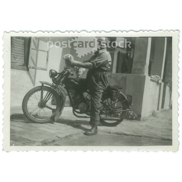 1930s. Biker with a puppy. The creator of the picture and the person on it are unknown. Original paper image. Old photo. (2792656)